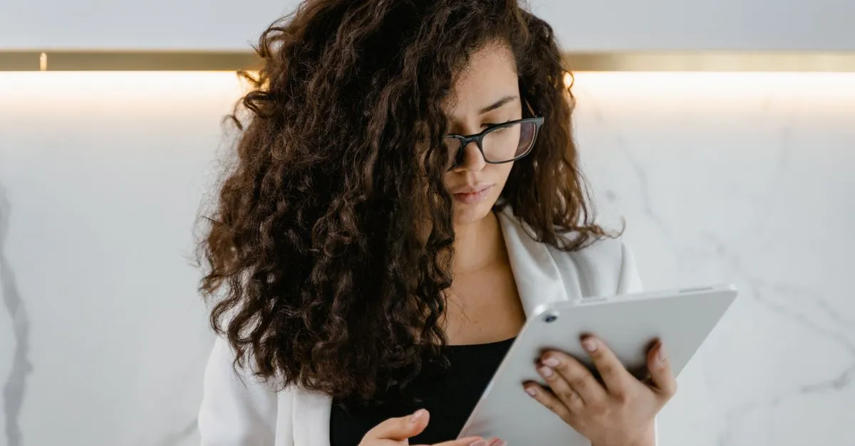 Empresária compreendendo dados de SEO em tablet, com apoio de um consultor SEO para PMEs.